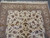 Angled view of the 6 by 9 ivory rug corner with beige borders and fringe