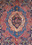 Close-up of the sky blue central medallion with red palmettes, ivory scrolls and pink blossoms