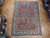 Salmon 7x10 Persian Tabriz rug displayed flat on herringbone parquet in the Freeport showroom