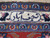 Woven ivory cartouche in Persian script reading Najaf Abad within the blue guard border stripe