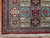 Corner detail showing red guard borders, navy panels and fine knotting on this Persian Qum rug