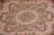Detail of the scalloped cartouche medallion framed by sage leaf garlands and pink blossoms