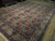 9' x 12'10" Persian Bakhtiar rug photographed at an angle, ivory border and blue guard stripes visible