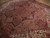 Angled floor view of semi-antique Persian rug showing terracotta field, navy border and ivory corners