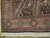 Corner detail of burgundy and ivory border with turquoise cartouches, black field and ivory fringe