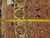 Tape measure laid across the ivory border showing scale of knots, fringe and motifs