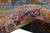 Wool pile curled to show thickness, ivory border with red hooked motifs and yellow accents