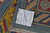 Back tag confirming hand-knotted in Pakistan, 100% natural wool, size 14.3 by 10.2 feet