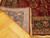 Folded corner revealing the hand-knotted back, cotton foundation and ivory fringe of this Persian rug