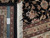 Ruler and authentic hand knotted tag on the 9x12 rug showing fine knots per square inch