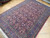 Angled floor view showing salmon and wine tones, ivory flower heads and five band border