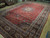 10'11 x 17 Persian Tabriz rug photographed at an angle revealing the dense allover floral field