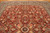 Close view of rose, sage green and ivory blossoms scattered across the deep red field