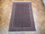 6'7" x 10' Persian Tabriz rug lying flat on parquet floor showing full all-over design