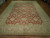 Large 12x18 Ziegler design rug photographed at an angle, all-over floral field and beige border