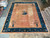 12' x 15'4" Chinese Art Deco rug shown flat on a warehouse showroom floor