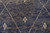 Detail of ivory cross motifs and freehand lattice lines across striated charcoal blue wool