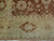 Corner detail showing gold main border, red rosette guard stripe and brown cartouche motif in wool