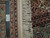 8 x 10 Sino Tabriz rug shown with ruler and authentic hand knotted tag beside ivory fringe