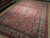 Large 10x14 Persian Sarough rug angled on showroom floor, all over floral field visible