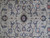 Close-up of navy rosette, sky blue palmettes and fine wool knotting in the field