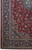 Corner detail showing navy border, ivory guard stripes and curvilinear arabesque spandrel on red ground