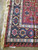 Close-up of border rosettes, ivory guard stripe and clean selvedge on a red flat weave
