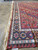 Corner of the rug showing ivory fringe, latch-hook outer band and geometric medallion border