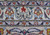 Close-up of the woven signature cartouche in the main border, flanked by vase and blossom motifs