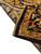 Folded corner showing the back, dark outer border and original warp fringe in gold tones