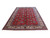 Signed 9'10" x 15'11" Persian Tabriz rug photographed at an angle showing ivory border and red field