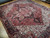 Angled floor photo showing the 10x12 Heriz rug on parquet with soft rose red field