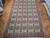 9'4" x 19'10" Chinese needlepoint rug laid over herringbone parquet floor in the warehouse showroom