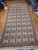 9x20 oversize green needlepoint rug shown full length on parquet, repeating framed floral panel grid