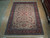 Full view of the 9'1" x 12'4" traditional rug lying on light hardwood showroom floor