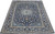 Angled full view of navy blue Kashan rug showing ivory border and dense floral field