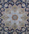 Close-up of sage green 8 point medallion with salmon rosette center on navy Kashan field