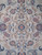 Close-up of lobed central medallion with rose, navy and sky blue blossoms on sage ground