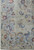Corner detail showing large paisley boteh motifs, scrolling vines and open greenish grey wool field