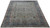 9'10" x 13'2" Kashan rug photographed at an angle showing soft green field and ivory guard borders