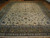 Full view of 10'9" x 15'3" Kashan rug on parquet floor showing ivory field and borders