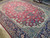 Oversize 10 x 15 Persian rug at an angle showing blue palmettes and ivory cartouche corners