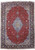 Full overhead view of red Persian Isfahan rug with pastel blue medallion and navy floral border