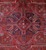 Close-up of the stepped medallion with slate blue, olive and rose accents on brick red wool
