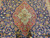 Central ivory and red medallion framed by navy field densely drawn with roses and palmettes