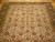 Ivory field filled with rosettes, palmettes and curling vines in gold, olive and rust