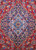 Close-up of the ivory and navy lobed medallion with sky blue palmettes on red ground