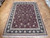 Hand-knotted 8'6" x 11'6" Oriental rug on parquet floor showing dense all-over floral field