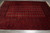 Angled overhead view of hand-knotted wool Bokhara rug showing dense gul rows and dark elem panels
