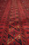 Border detail showing triangular motifs, geometric guard stripes and thick wool pile in rust tones